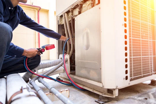 Technician inspecting the lines of an outdoor unit