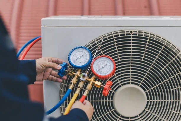 Refrigerant gauges connected to an outdoor AC unit